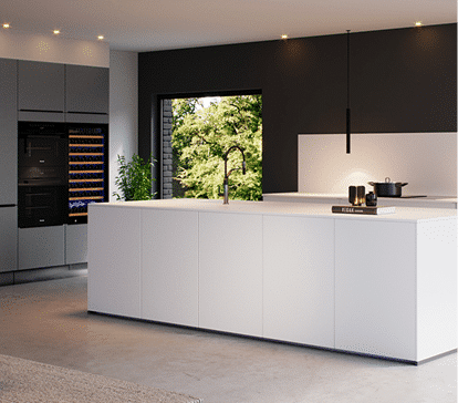 Îlot de cuisine blanc avec évier intégré, entouré de mobilier gris, plante verte, et fenêtre donnant sur un jardin.