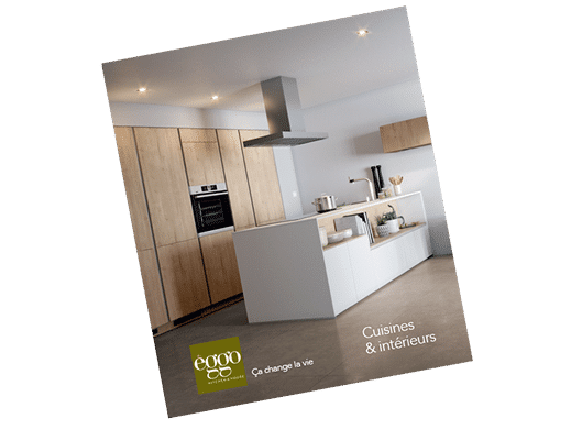 Cuisine moderne avec îlot central blanc, armoires en bois clair, hotte en acier inoxydable et éclairage encastré au plafond.