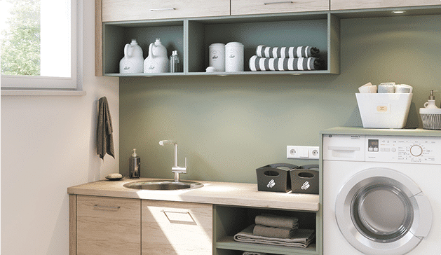 Une buanderie moderne avec une machine à laver blanche, un évier inox, des étagères vertes et des accessoires de rangement blancs et noirs.