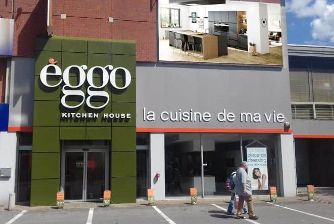 Façade d'un magasin Èggo avec enseigne verte et slogan "la cuisine de ma vie", devanture en verre et panneau publicitaire de cuisine moderne.