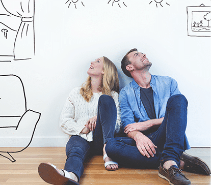 Un homme et une femme assis par terre regardent vers le haut, entourés de dessins de meubles et de décorations sur le mur blanc.