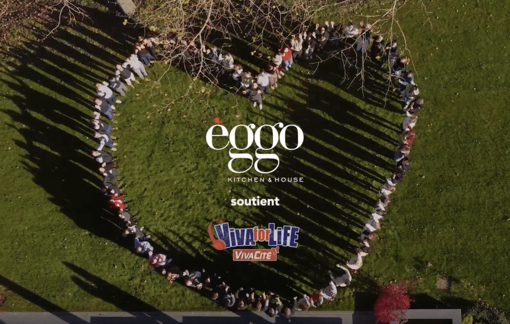 Groupe de personnes qui forment un coeur avec, au centre le messag e: "èggo Kitchen & House soutient Viva For Life VivaCité".